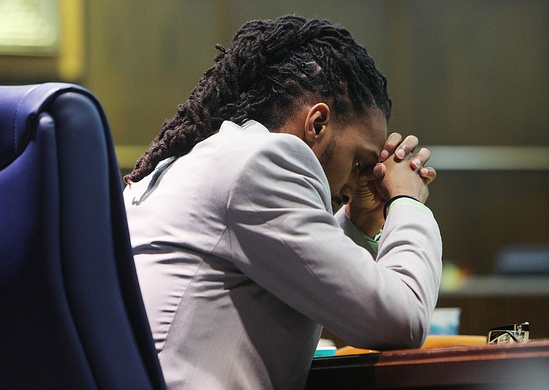 Johnthony Walker sits quietly to himself during a brief recess in his criminal trial Tuesday, Feb. 27, 2018 in Judge Don Poole's courtroom at the Hamilton County Courthouse in Chattanooga, Tenn. Walker is standing trial for the Nov. 21, 2016 bus crash in which six of the 37 Woodmore Elementary School students on board died.