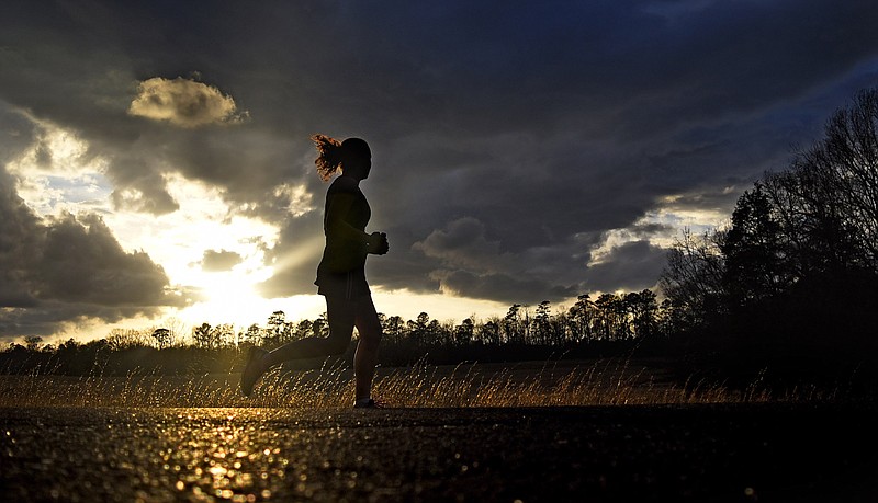 As the sun sets a runner looks to the western sky as she jogs along Glenn-Kelly Road in Chickamauga National Military Park on February 21, 2018.  With the recent warm weather the park's roads have been a haven for athletes of all sorts.  