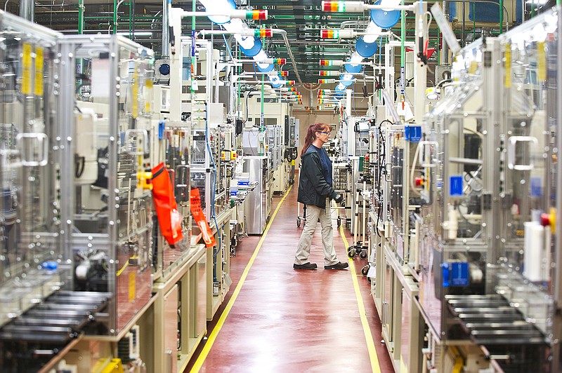 An employee of Denso's Athens, Tenn., manufacturing plant walks by a production line.