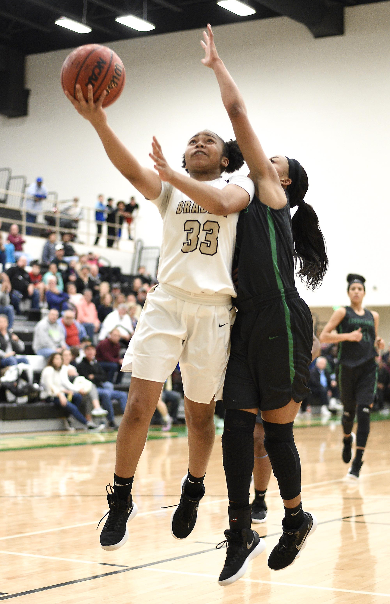 Bradley Central's Jamaryn Blair (33) goes in for a layup and is fouled by East Hamilton's DeZah Lacy during the Region 3-AAA championship game Wednesday night at Rhea County. Blair scored 16 points as Bradley won 74-31.