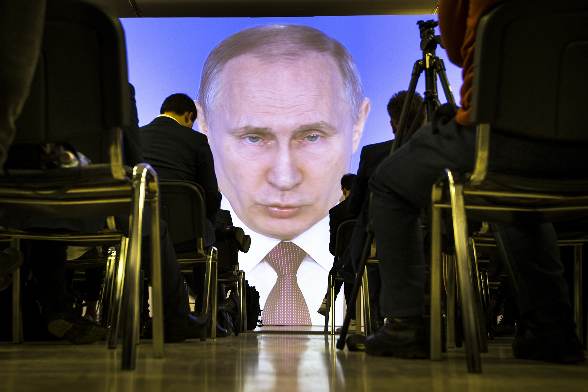 Journalists watch as Russian President Vladimir Putin gives his annual state of the nation address in Manezh in Moscow, Russia, Thursday, March 1, 2018. Putin set a slew of ambitious economic goals, vowing to boost living standards, improve health care and education and build modern infrastructure in a state-of-the-nation address. (AP Photo/Alexander Zemlianichenko)