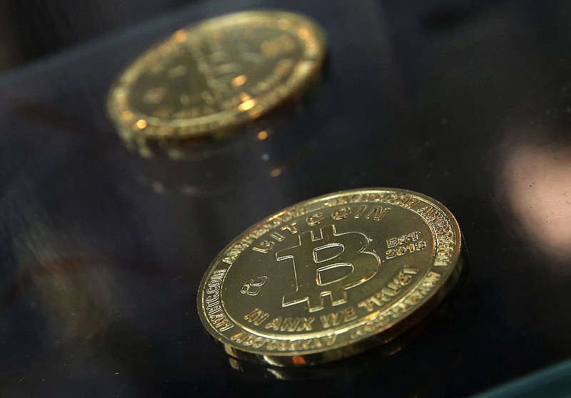Coins are displayed next to a Bitcoin ATM in Hong Kong. The IRS says that cryptocurrency transactions are taxable by law. That means people who made money (or lost it) on Bitcoin trades, "mined" Ethereum or even bought a cup of coffee with digital currency face potential tax implications. Failure to report it could mean potential audits, fines and penalties. (AP Photo/Kin Cheung, File)