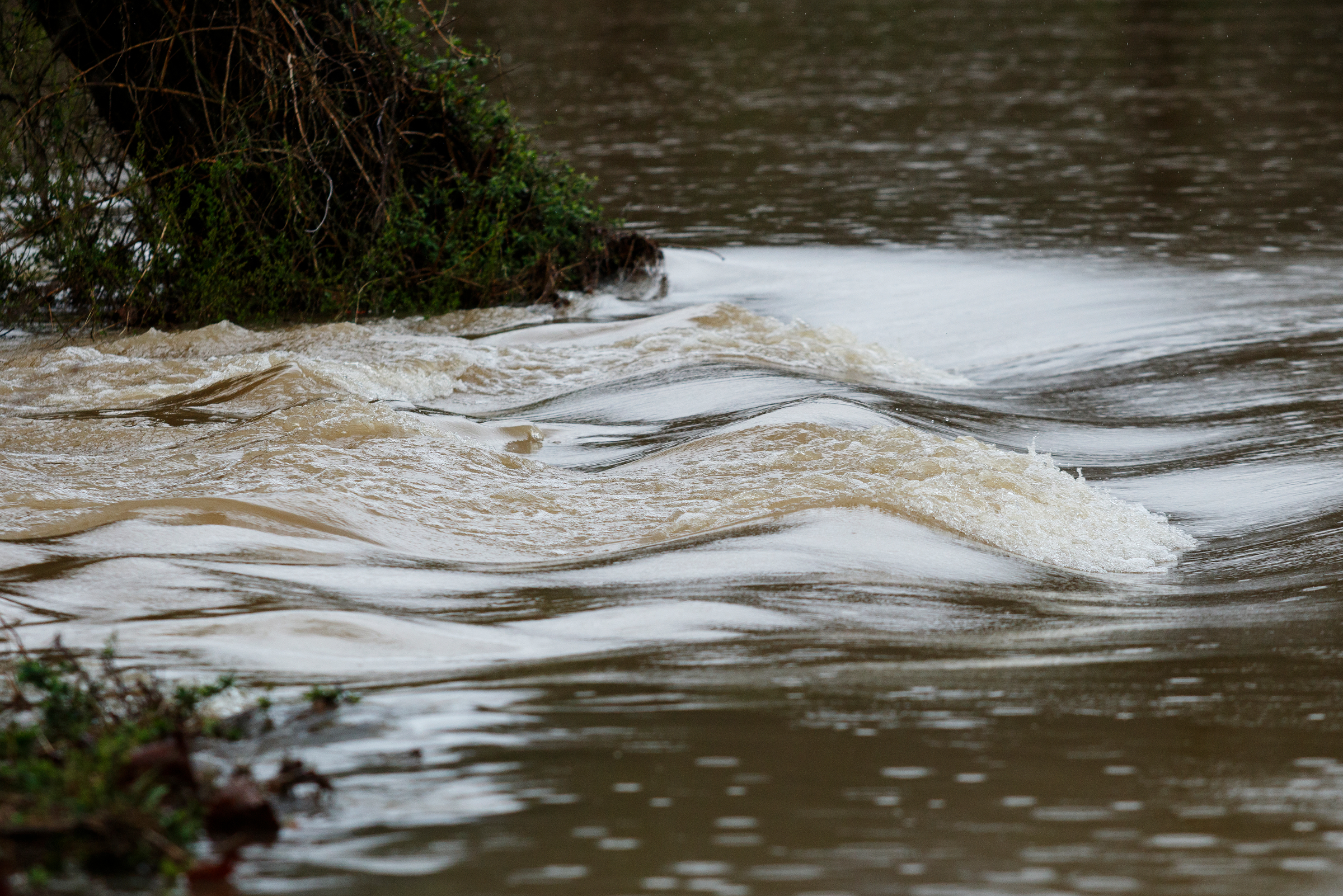 Water flows across an impassible section of Creek Road as Lookout Creek overflows after heavy rainfall caused flooding throughout the region Thursday, March 1, 2018, in Wildwood, Ga.