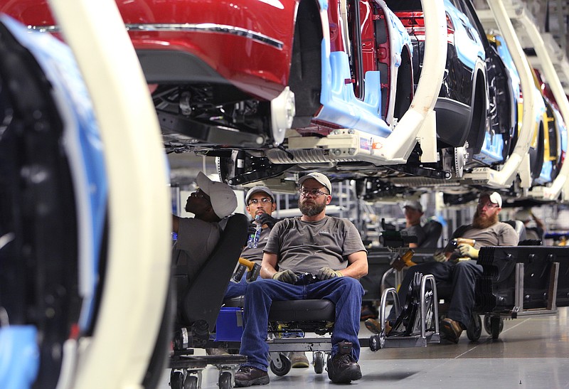 Staff file photo by Erin O. Smith / Volkswagen employees rest for a moment as they await the next vehicle on the assembly line at the automaker's Chattanooga assembly plant.