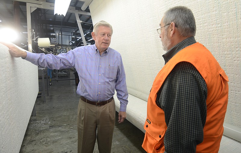 In this 2013 file photo, Chairman and CEO Dan Frierson, left, and plant manager Dan Williams talk about a new lighting system that better shows the carpets at the Dixie Group in North Georgia.