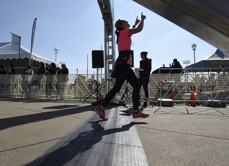 A woman points to the sky as she crosses the finish line during the first running of the Chattanooga Marathon on Sunday, Mar. 6, 2016, in Chattanooga, Tenn. 