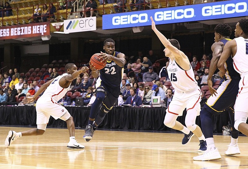 UTC junior Makinde London drives to the basket during Friday night's SoCon tournament game against Samford in Asheville, N.C. London had 25 points, 14 rebounds, four assists, three steals and two blocks to lead the Mocs to an 89-79 win.