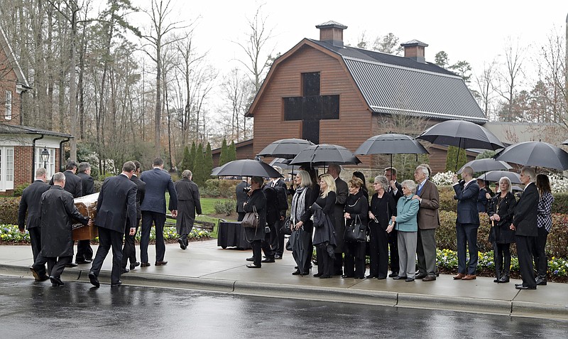Pallbearers carry the casket of Rev. Billy Graham past family members as it returns to the Billy Graham Library in Charlotte, N.C., Thursday, March 1, 2018. (AP Photo/Chuck Burton)
