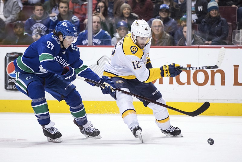 Nashville Predators' Mike Fisher, right, skates with the puck while being checked by Vancouver Canucks' Ben Hutton during the first period of an NHL hockey game Friday, March 2, 2018, in Vancouver, British Columbia. (Darryl Dyck/The Canadian Press via AP)