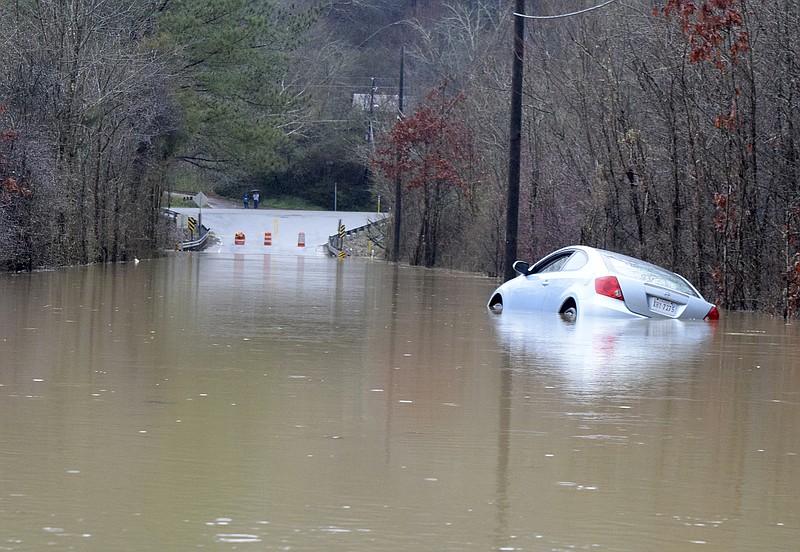 An abandoned car sits partially submerged in the flood waters of Mackey Branch on Davidson Road in early February 2016.