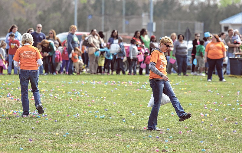 Venue Church volunteers kick eggs to spread them out before an Easter egg hunt the chuch sponsored at Camp Jordan Park in East Ridge in April 2014.