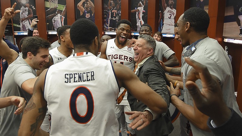 Auburn basketball coach Bruce Pearl celebrates with players following Saturday afternoon's 79-70 win over South Carolina that clinched the program's first SEC title since 1999. Auburn is the top seed in this week's league tournament in St. Louis.