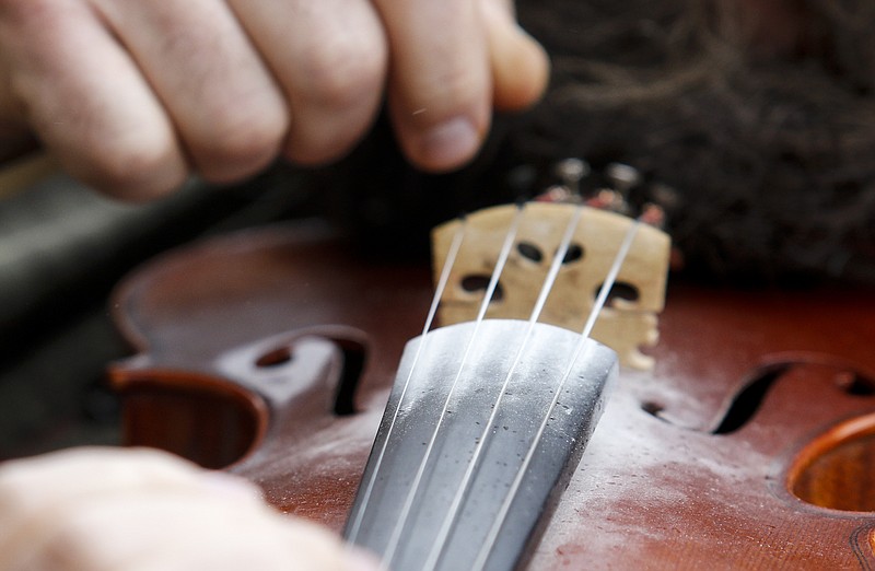 Rosin is collected on the fingerboard as Philip Stewart tunes his violin Saturday, March 14, 2015, at the 6th Annual Great Southern Old Time Fiddlers Convention at Lindsay Street Hall in Chattanooga, Tenn. The convention draws musicians from across the region to play together and compete in musical competitions.