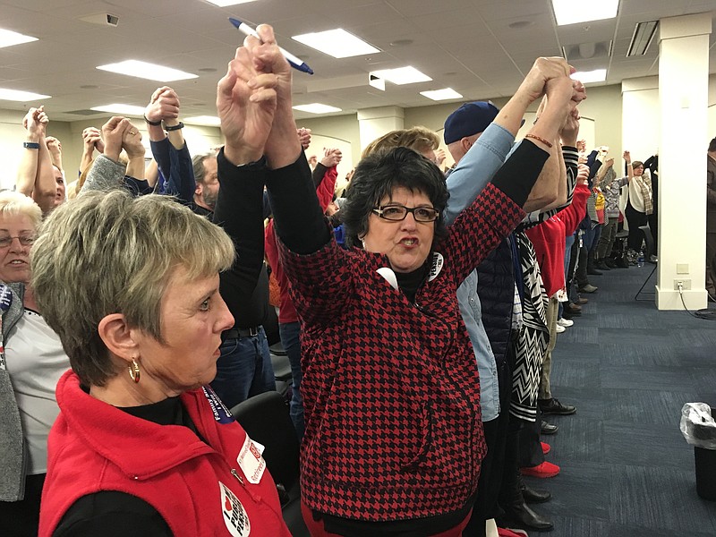 Retired teacher Meg Judd raises her arms and chants "Find funding first!" during a legislative committee hearing in Frankfort, Ky., Wednesday, March 7, 2018. 