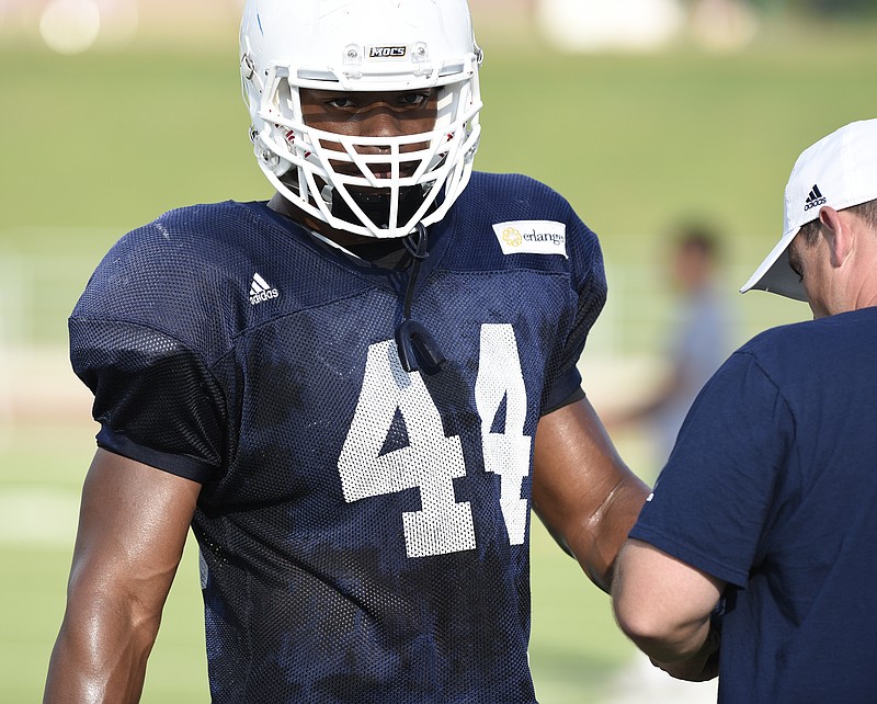 UTC outside linebacker Khayyan Edwards (44) gets tape added to his wrist during a practice at Finley Stadium on Aug. 10, 2017.