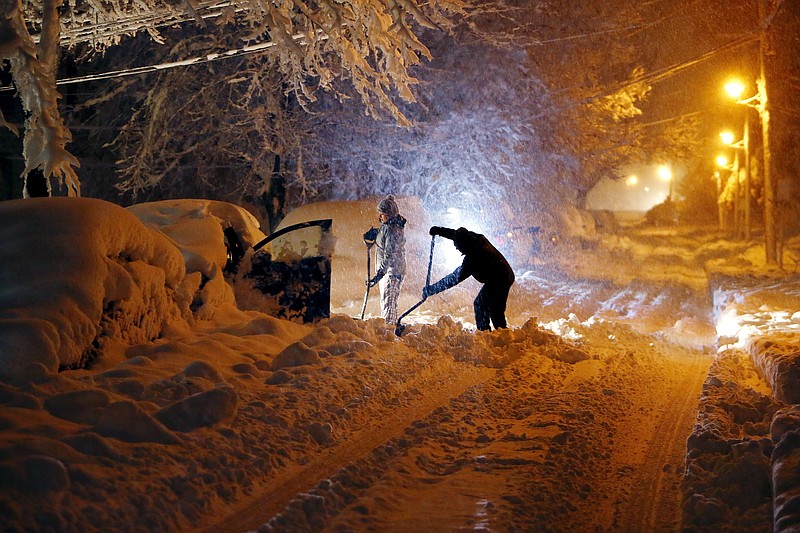 Residents on Mills Street dig out their car after a snowstorm dumped over a foot of snow around the area Wednesday, March 7, 2018, in Morristown, N.J. The storm carrying wind, rain and heavy snow was expected to continue into Wednesday night. (Bob Karp/The Record via AP)