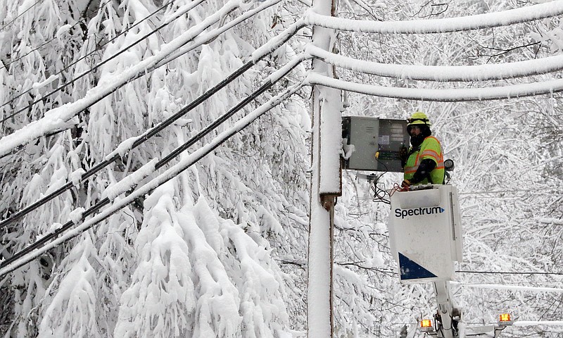 A lineman works to restore power amid limbs sagging with heavy wet snow after a snowstorm, Thursday, March 8, 2018, in Northborough, Mass. The storm produced heavy, wet snow that brought down tree limbs and power lines. (AP Photo/Bill Sikes)