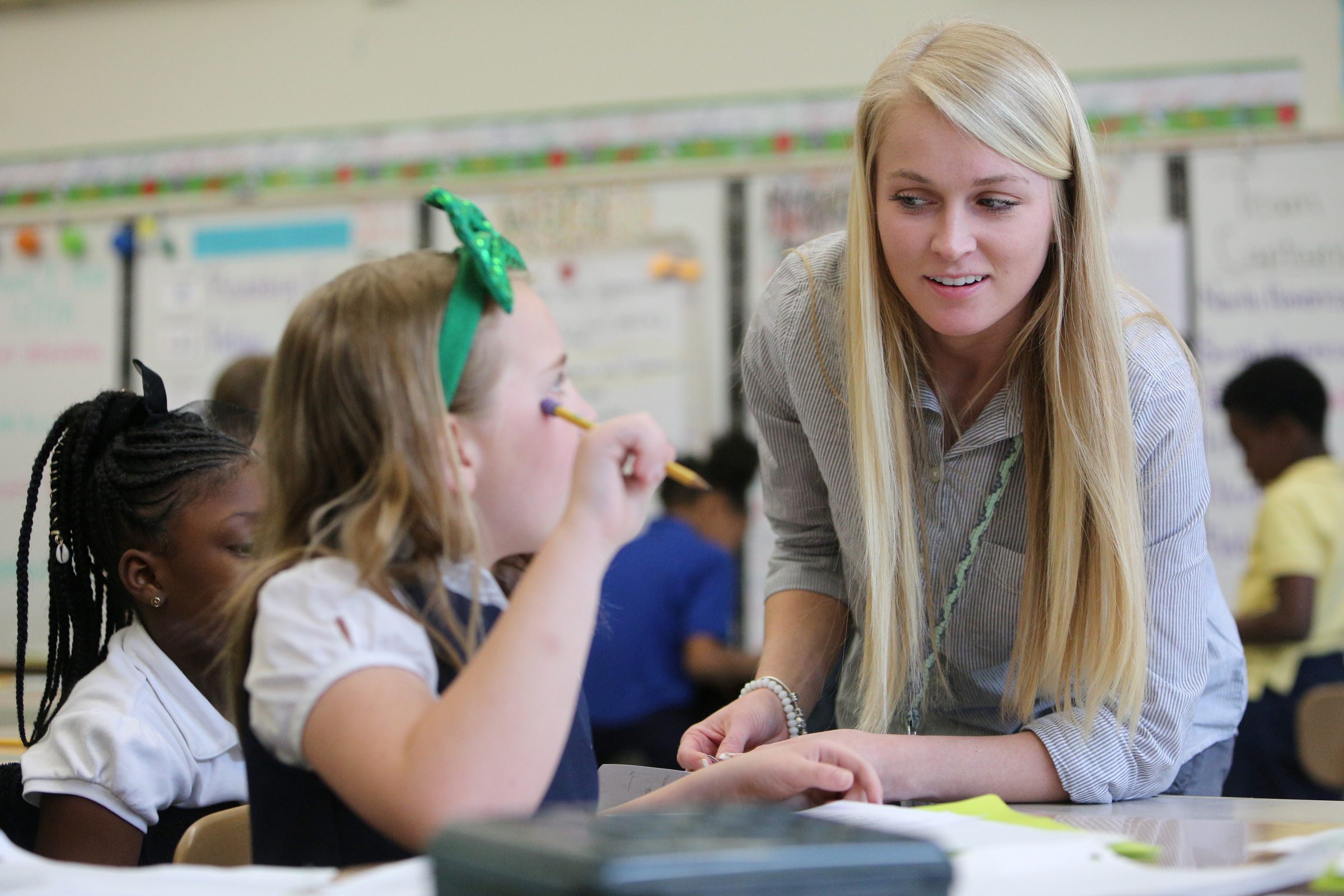 Emily Reed, 9, gets help from Christin Willingham, a student teacher from the University of Tennessee at Chattanooga, in Wendy Scruggs' class at Battle Academy Wednesday, March 7, 2018 in Chattanooga, Tenn. UTC is changing how it prepares students to be teachers by expanding the length of time students spend as student teachers during their residency semesters.