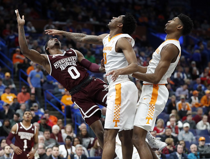 Mississippi State's Nick Weatherspoon (0) goes up for a layup past Tennessee's Jordan Bowden and Kyle Alexander, right, during the second half of an NCAA college basketball game in the quarterfinals of the Southeastern Conference tournament, Friday, March 9, 2018, in St. Louis. Weatherspoon was injured on the play and taken off on a stretcher. (AP Photo/Jeff Roberson)