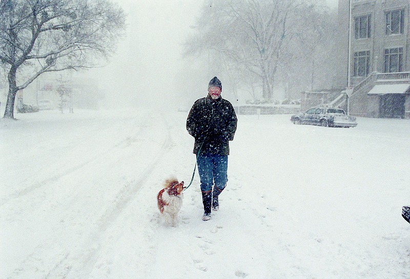 As snow continues to fall, Ken Axsiom walks his dog, Peaches, down the middle of Georgia Avenue near the Hamilton County Courthouse Saturday morning, April 13, 1993. "The Blizzard of 1993" blanketed the Chattanooga area with two feet of snow overnight. 
