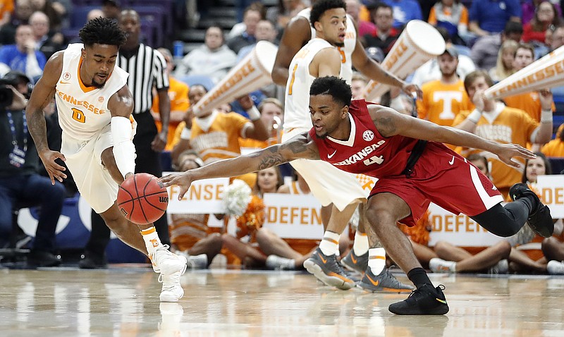 Tennessee's Jordan Bone, left, and Arkansas' Daryl Macon dive after a loose ball during the first half of an NCAA college basketball game in the semifinals of the Southeastern Conference tournament Saturday, March 10, 2018, in St. Louis. (AP Photo/Jeff Roberson)