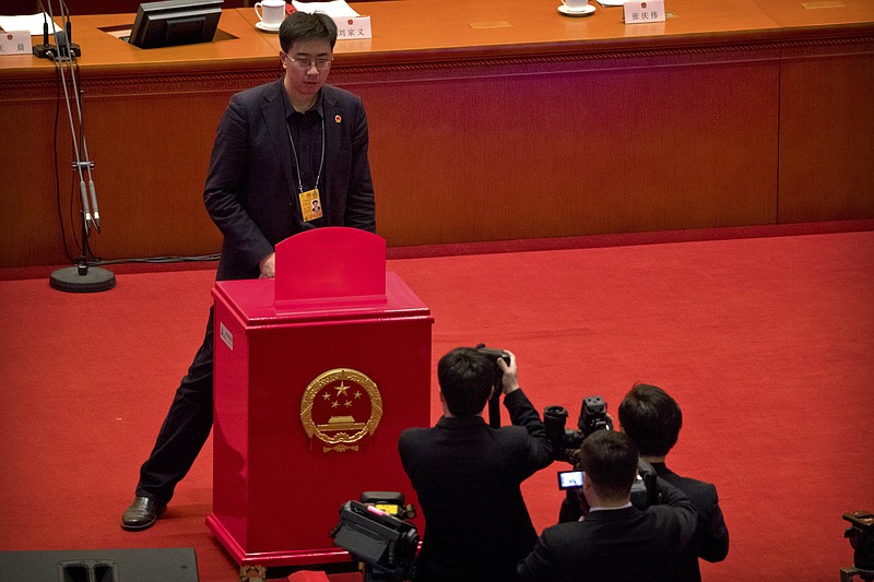 
              A staff member stands in front of a ballot box on the rostrum before a plenary session of China's National People's Congress (NPC) at the Great Hall of the People in Beijing, Sunday, March 11, 2018. China's top legislative body is expected to approve an amendment too China's constitution on Sunday that will abolish term limits on the presidency and enable Chinese President Xi Jinping to rule indefinitely. (AP Photo/Mark Schiefelbein)
            