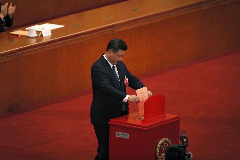 Chinese President Xi Jinping casts his vote for an amendment to China's constitution that will abolish term limits on the presidency and enable him to rule indefinitely, during a plenary session of the National People's Congress at the Great Hall of the People in Beijing, Sunday, March 11, 2018. (AP Photo/Andy Wong)