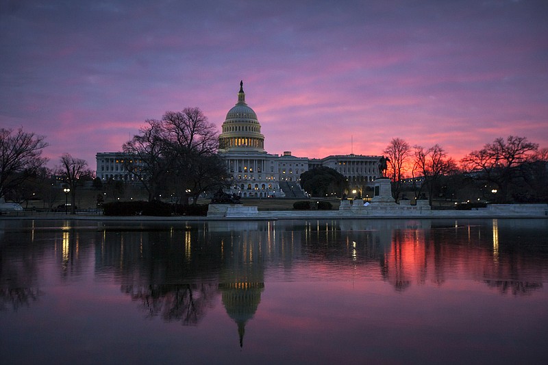 FILE - In this Feb. 6, 2018, file photo, dawn breaks over the Capitol in Washington. The once bipartisan drive to curb increases in health care premiums has devolved into a partisan struggle with escalating demands by each side. It’s unclear they’ll be able to reach an agreement. And the two parties may end up blaming each other this fall as states announce next year’s inevitably higher insurance rates _ just weeks before Election Day on Nov. 6. (AP Photo/J. Scott Applewhite, File)