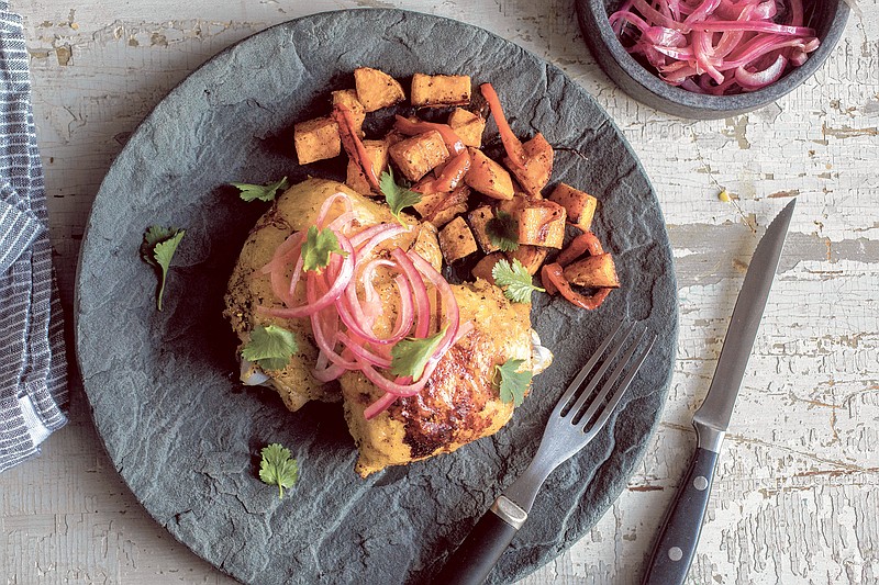 In this recipe, chicken, bell peppers and sweet potatoes are roasted together on a sheet pan, then sparked with pickled onions. (Andrew Scrivani/The New York Times)