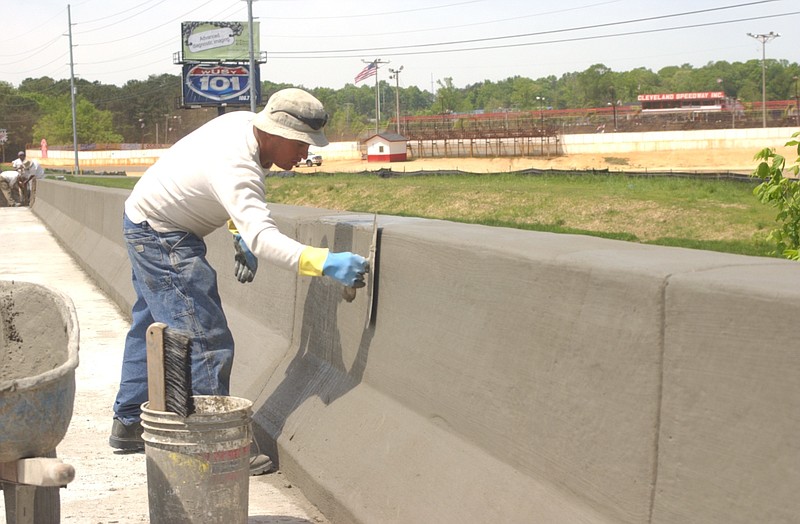 In this 2005 staff file photo, Simpson Construction employee Edgar Salinas smooths concrete on a parapet wall over Candies Creek as Tennessee Department of Transportation crews work to finish bridge widening on South Lee Highway near the Cleveland Speedway.