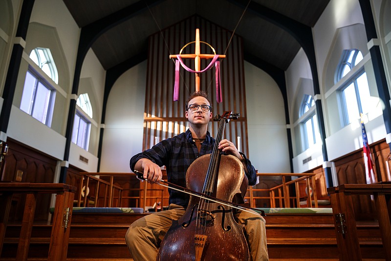 Cellist Ben Sollee warms up before performing for students during a workshop at St. Peter's Episcopal School on Tuesday, March 13, 2018, in Chattanooga, Tenn. Sollee, a musician known for touring by bicycle, offered students an introduction to the musical sounds of the cello while also talking about his journey to find his own musical voice.