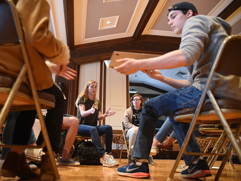 Inside St. Paul's Episcopal Church Sunday afternoon, GPS student Nikki Goldbach, back left, directs during a breakout session of students discussing plans for the National Student Walkout on Wednesday, March 14. Katelyn Burns, back right, is a student at Sequoyah Vocational. Baylor student Trey Lydon, near right, passes his laptop to another student.