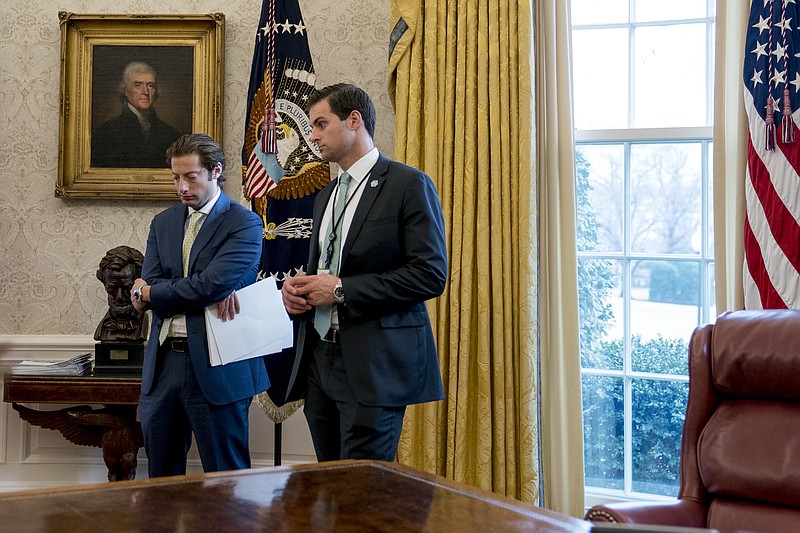  In this Jan. 31, 2018, file photo, White House aide John McEntee, right, and Treasury Secretary Steve Mnuchin's Chief of Staff Eli Miller, left, stand in the Oval Office as President Donald Trump speaks at a tax reform meeting with American workers at the White House in Washington. Trump's personal aide is leaving the White House and will rejoin his campaign. (AP Photo/Andrew Harnik)