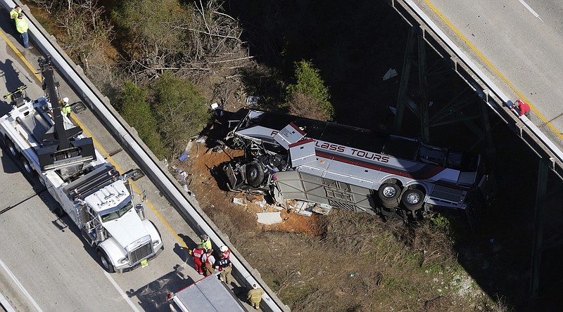 Rescue crews work at the scene of a deadly charter bus crash on Tuesday, March 13, 2018, in Loxley, Ala. The bus carrying Texas high school band members home from Disney World plunged into a ravine before dawn Tuesday. (AP Photo/Dan Anderson)

