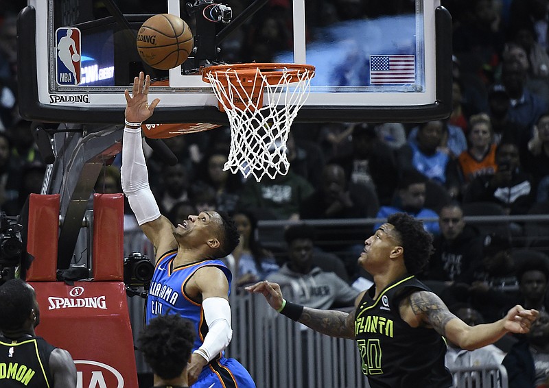 Oklahoma City Thunder guard Russell Westbrook shoots a reverse layup as Atlanta Hawks forward John Collins (20) defends during the first half of an NBA basketball game, Tuesday, March 13, 2018, in Atlanta. (AP Photo/John Amis)