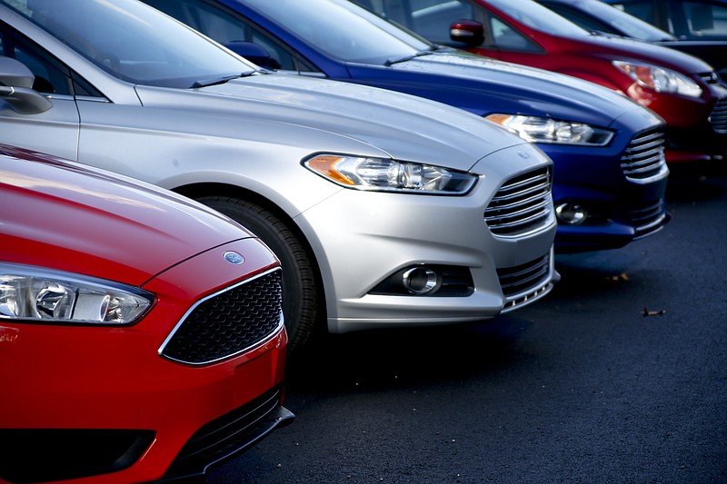 FILE- In this Nov. 19, 2015, photo, a row of new Ford Fusions are for sale on the lot at Butler County Ford in Butler, Pa. Under pressure from U.S. regulators, Ford is recalling nearly 1.4 million midsize cars in North America because the steering wheels can detach from the steering column and drivers could lose control. The recall covers certain Ford Fusion and Lincoln MKZ cars from the 2014 through 2018 model years. (AP Photo/Keith Srakocic, File)