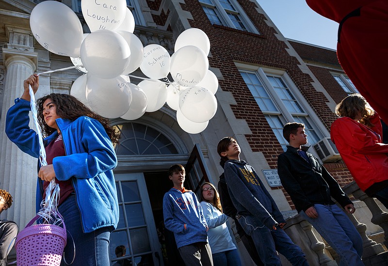 Sophie Albaraket holds 17 balloons in memory of victims of a school shooting in Parkland, Fla., as students walk out of Chattanooga School for the Arts and Sciences in protest on Wednesday, March 14, 2018, in Chattanooga, Tenn. Students across the region and the country walked out of school at 10 a.m. to protest gun violence in the wake of a school shooting in Florida that killed 17.