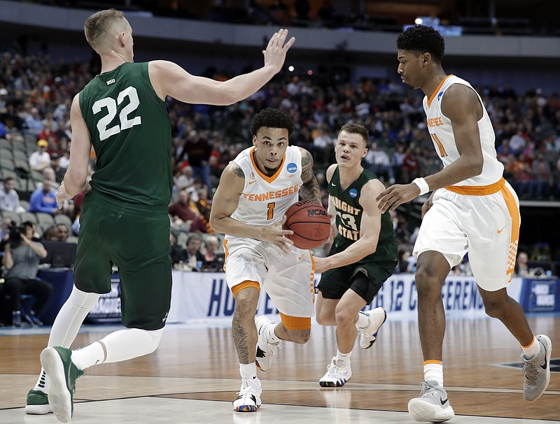 Tennessee's Lamonte Turner, center, drives to the basket as Wright State's Parker Ernsthausen (22) closes in during their NCAA tournament opener Thursday afternoon in Dallas. Turner had 19 points and nine assists to help the third-seeded Vols advance with a 73-47 win.