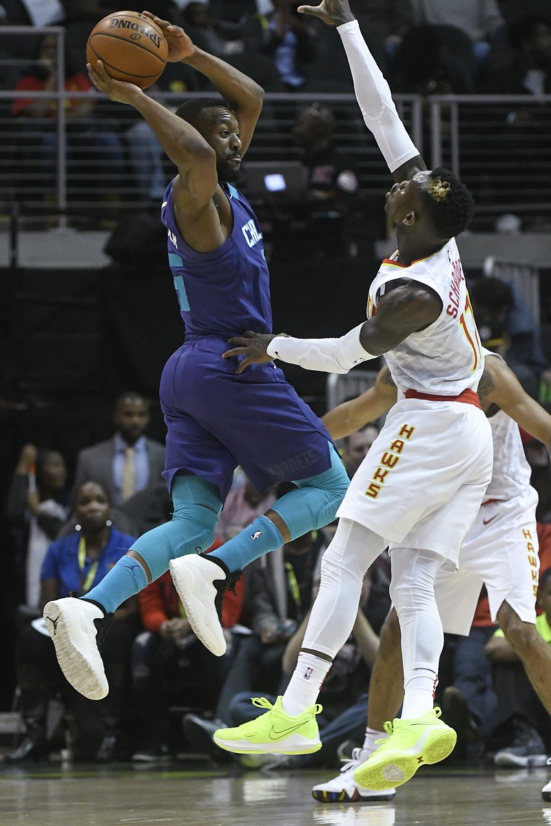 Charlotte Hornets guard Kemba Walker looks to pass as Atlanta Hawks guard Dennis Schroder (17) guards him during the first quarter of an NBA basketball game Thursday, March 15, 2018, in Atlanta. (AP Photo/John Amis)
