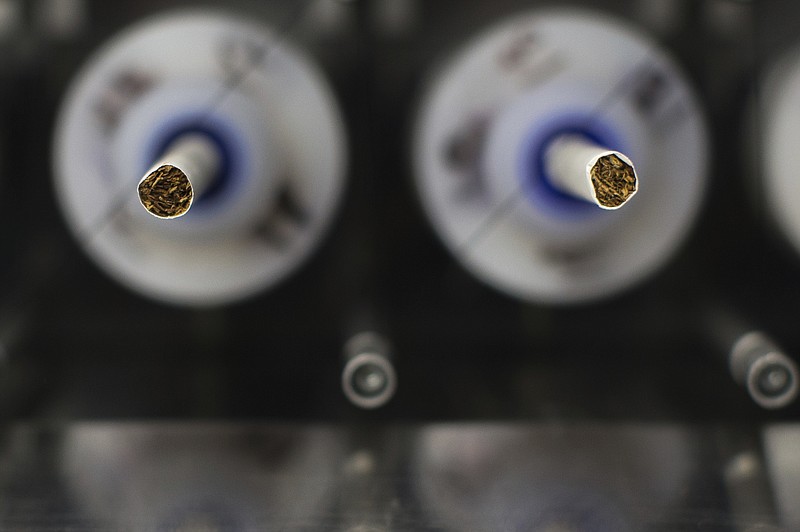 In this Thursday, Nov. 10, 2016, file photo, test cigarettes sit in a smoking machine in a lab at the Centers for Disease Control and Prevention in Atlanta. On Wednesday, March 14, 2018, the U.S. Food and Drug Administration announced a sweeping anti-smoking plan to drastically cut nicotine levels in cigarettes. (AP Photo/Branden Camp)