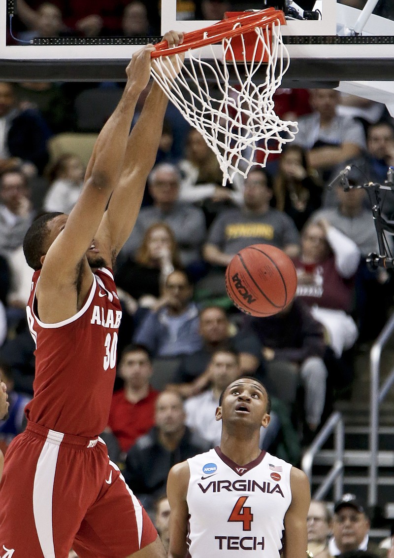 Alabama's Galin Smith (30) dunks in front of Virginia Tech's Nickeil Alexander-Walker (4) during the first half of an NCAA men's college basketball tournament first-round game Thursday, March 15, 2018, in Pittsburgh. (AP Photo/Keith Srakocic)