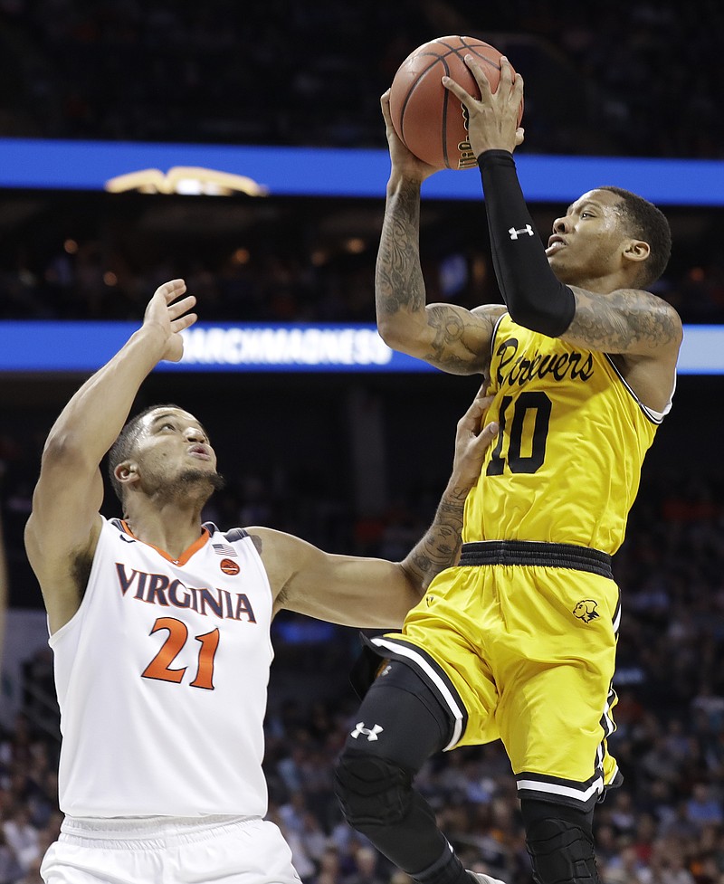 UMBC's Jairus Lyles (10) shoots over Virginia's Isaiah Wilkins (21) during the second half of a first-round game in the NCAA men's college basketball tournament in Charlotte, N.C., Friday, March 16, 2018. (AP Photo/Gerry Broome)