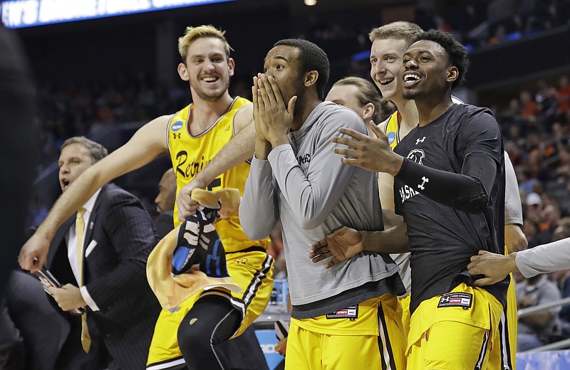 UMBC players celebrate a teammate's basket against Virginia during the second half of a first-round game in the NCAA men's college basketball tournament in Charlotte, N.C., Friday, March 16, 2018. (AP Photo/Gerry Broome)