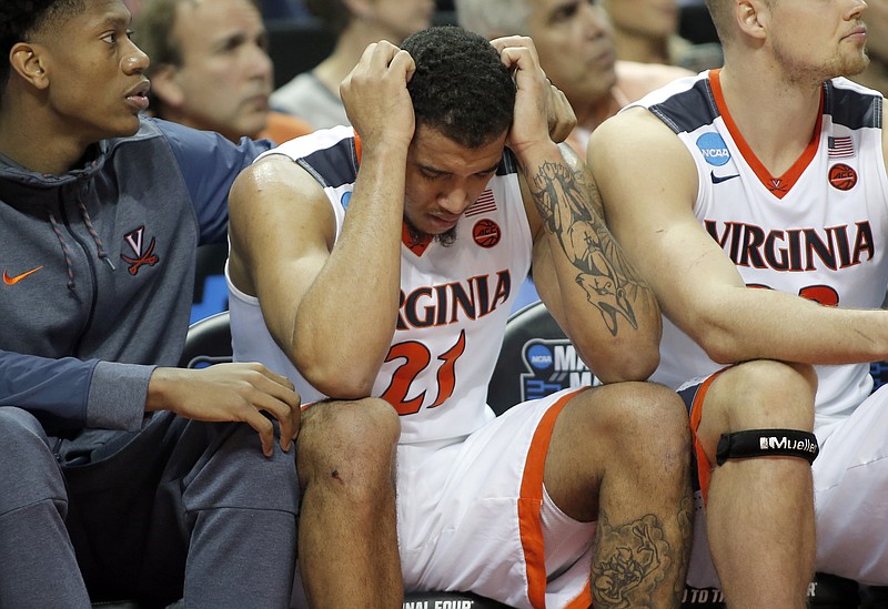 Virginia's Isaiah Wilkins (21) is consoled after fouling out during the second half of the team's first-round game against UMBC in the NCAA men's college basketball tournament in Charlotte, N.C., Friday, March 16, 2018. (AP Photo/Bob Leverone)