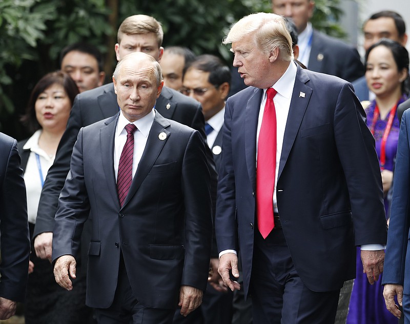 FILE - In this Nov. 11, 2017, file photo President Donald Trump, right, and Russia's President Vladimir Putin talk during the family photo session at the APEC Summit in Danang, Vietnam. (Jorge Silva/Pool Photo via AP, File)