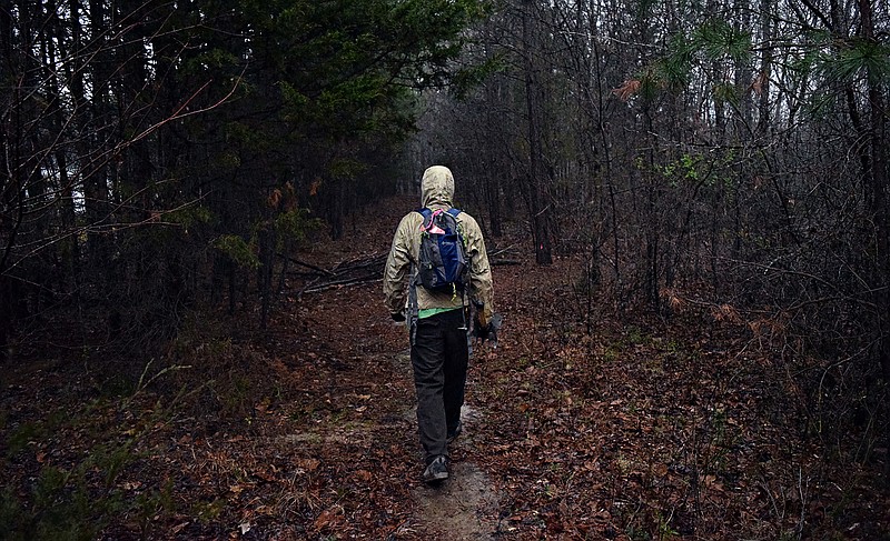 Photo by Mark Pace/Chattanooga Times Free Press, 3.17.18 — Volunteer Pendleton Sibley, 20, walks along a nearly-finished mountain bike trail at Enterprise South Nature Park. Volunteers gathered at the property for one of the final work days before the trail opens next month.