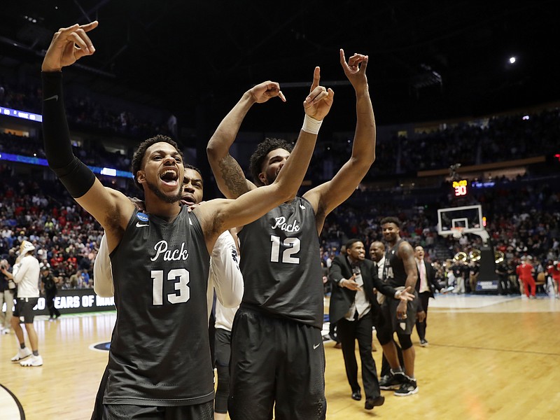 Nevada's Hallice Cooke (13) and Elijah Foster celebrate after the Wolf Pack's massive comeback victory against Cincinnati on Sunday night in Nashville.