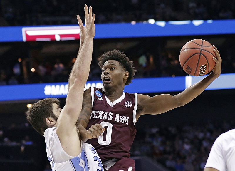 Texas A&M's Jay Jay Chandler (0) drives against North Carolina's Luke Maye (32) during the first half of a second-round game in the NCAA men's college basketball tournament in Charlotte, N.C., Sunday, March 18, 2018. (AP Photo/Gerry Broome)