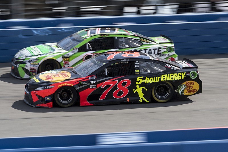Martin Truex Jr., foreground and Kyle Busch vie for the lead in the NASCAR Cup Series auto race Sunday, March 18, 2018. Truex won the race. (James Quigg/The Daily Press via AP)
