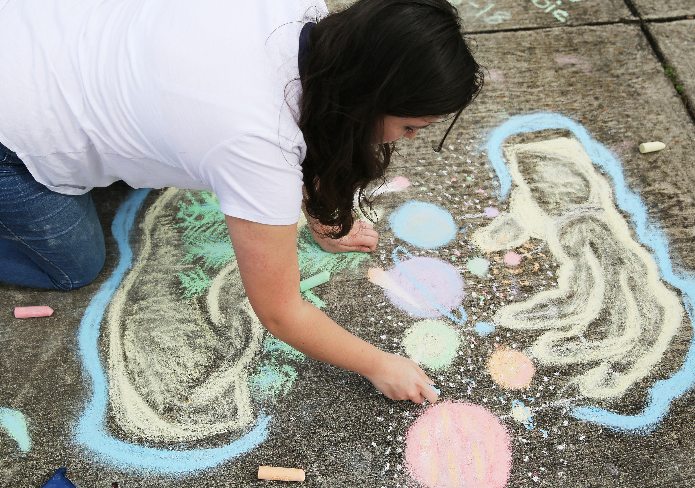 Trenity Newell, 15, draws planets dangling from a hand with sidewalk chalk at Gilbert-Stephenson Park during an interactive art walk pop-up event Sunday, March 18, 2018 in Fort Oglethorpe, Ga. Fort Oglethorpe is one of four cities chosen this year by the Thrive Regional Partnership to receive strategic assistance for the next 10 months from Bridge Innovate design professionals and other community members.
